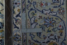 Backside of handmade 2000s Kashan rug showing knot structure and weave density