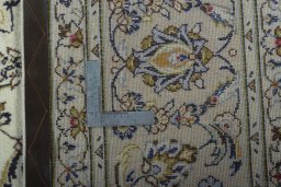 Backside of handmade 2000s Kashan rug showing knot structure and weave density