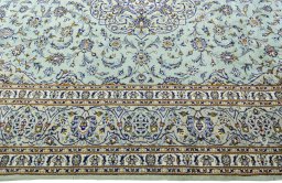 Corner detail of 2000s Kashan rug showing border pattern and Wool pile