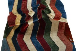 Corner detail of 2000s Persian Gabbeh rug showing border pattern and Wool pile