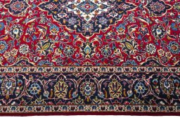 Corner detail of 2000s Kashan rug showing border pattern and Wool pile