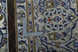 Backside of handmade 2000s Kashan rug showing knot structure and weave density