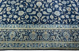 Corner detail of 2000s Kashan rug showing border pattern and Wool pile