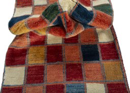Corner detail of 2000s Persian Gabbeh rug showing border pattern and Wool pile