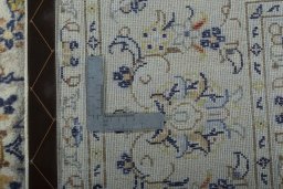 Backside of handmade 2000s Kashan rug showing knot structure and weave density