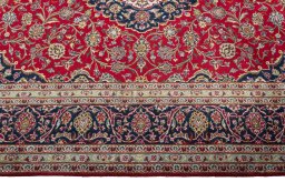Corner detail of 2000s Kashan rug showing border pattern and Wool pile