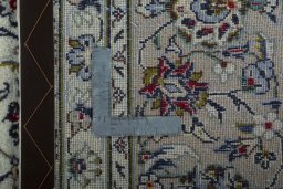 Backside of handmade 2000s Kashan rug showing knot structure and weave density