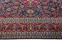 Corner detail of 2000s Kashan rug showing border pattern and Wool pile