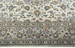 Corner detail of 2000s Kashan rug showing border pattern and Wool pile