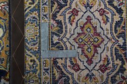 Backside of handmade 2000s Kashan rug showing knot structure and weave density
