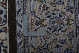 Backside of handmade 2000s Kashan rug showing knot structure and weave density