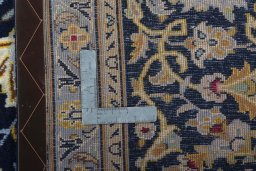 Backside of handmade 2000s Kashan rug showing knot structure and weave density
