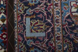 Backside of handmade 2000s Kashan rug showing knot structure and weave density