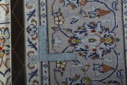Backside of handmade 2000s Kashan rug showing knot structure and weave density