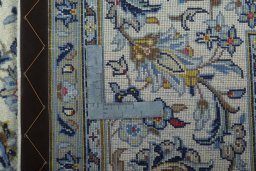 Backside of handmade New Kashan rug showing knot structure and weave density