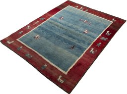 Corner detail of 2000s Persian Gabbeh rug showing border pattern and Wool pile