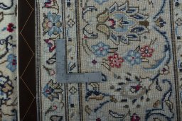 Backside of handmade 2000s Kashan rug showing knot structure and weave density
