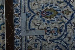 Backside of handmade 2000s Kashan rug showing knot structure and weave density