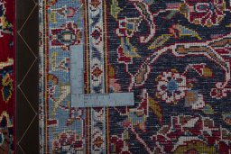 Backside of handmade 2000s Kashan rug showing knot structure and weave density
