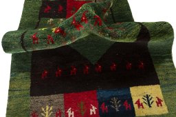 Corner detail of 2000s Persian Gabbeh rug showing border pattern and Wool pile