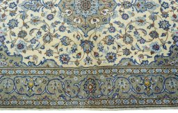 Corner detail of 2000s Kashan rug showing border pattern and Wool pile